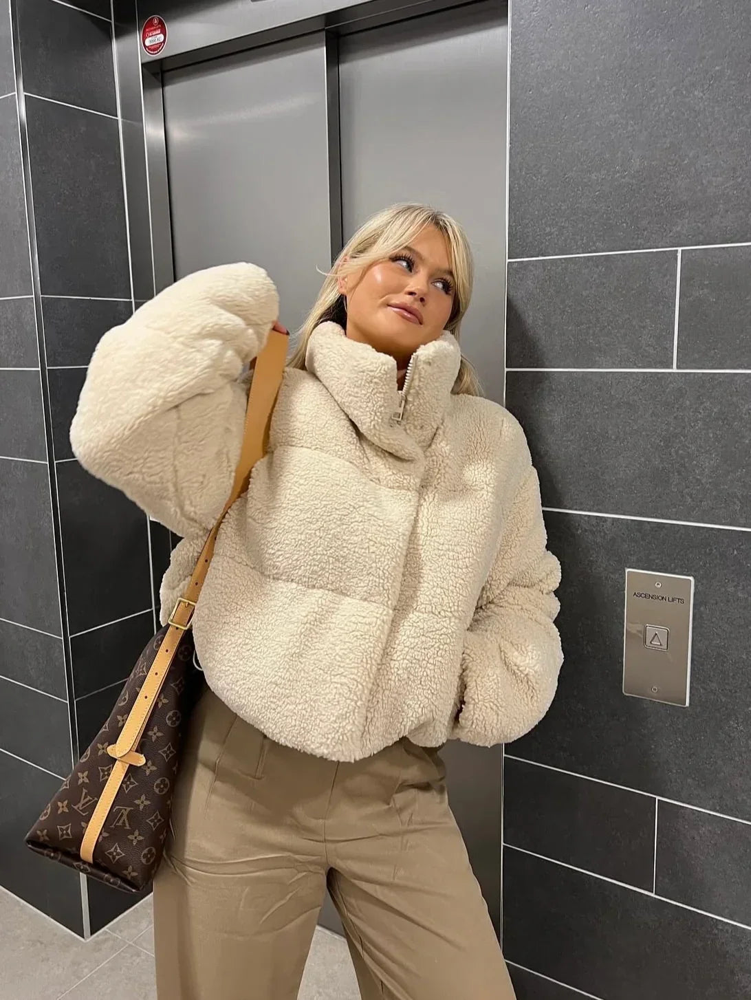 Beige oversized teddy puffer jacket with sherpa fleece texture and zip front