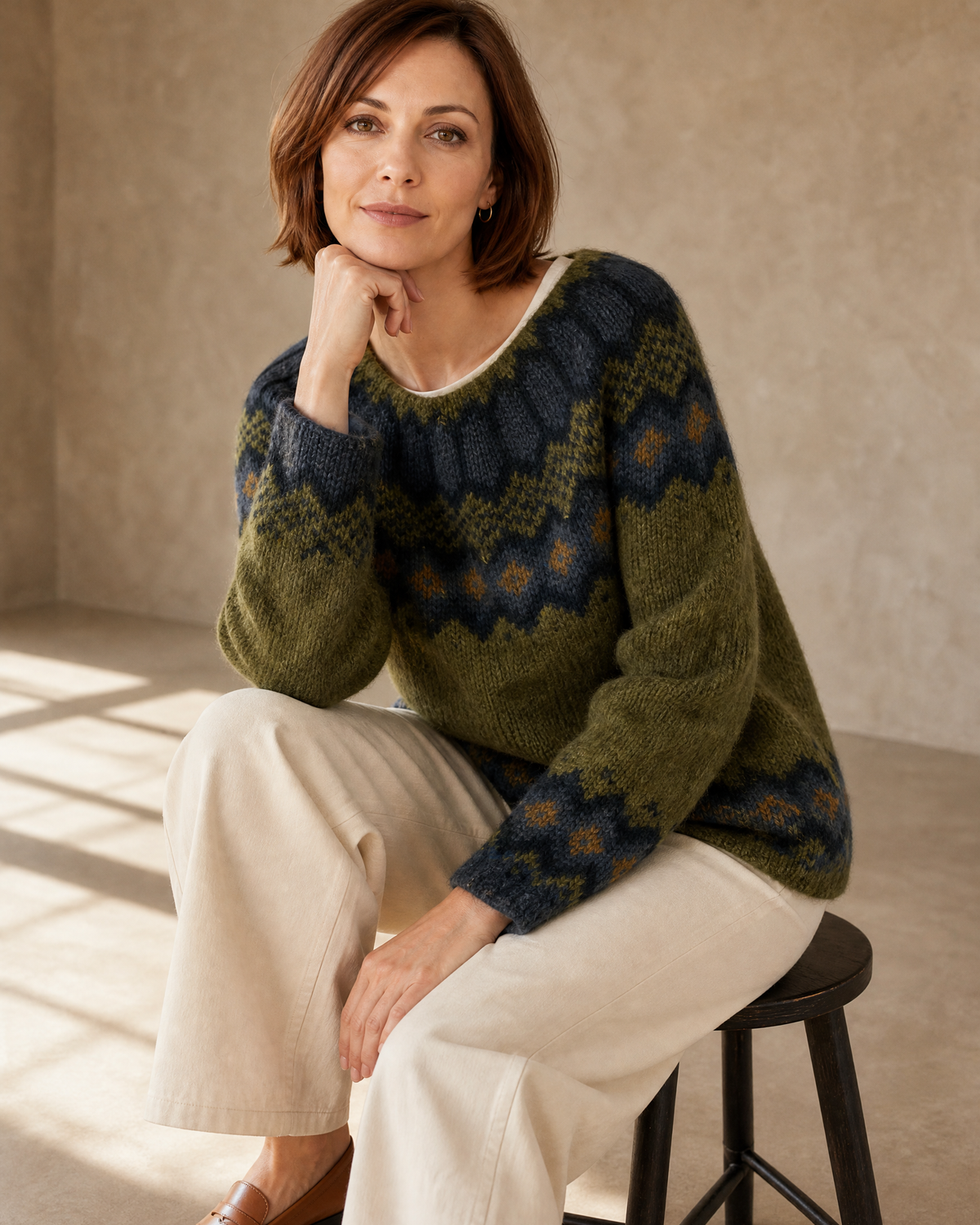 Women's Fashionable Pullover Sweater Top in Green, stool, elbow on knee, worn by model